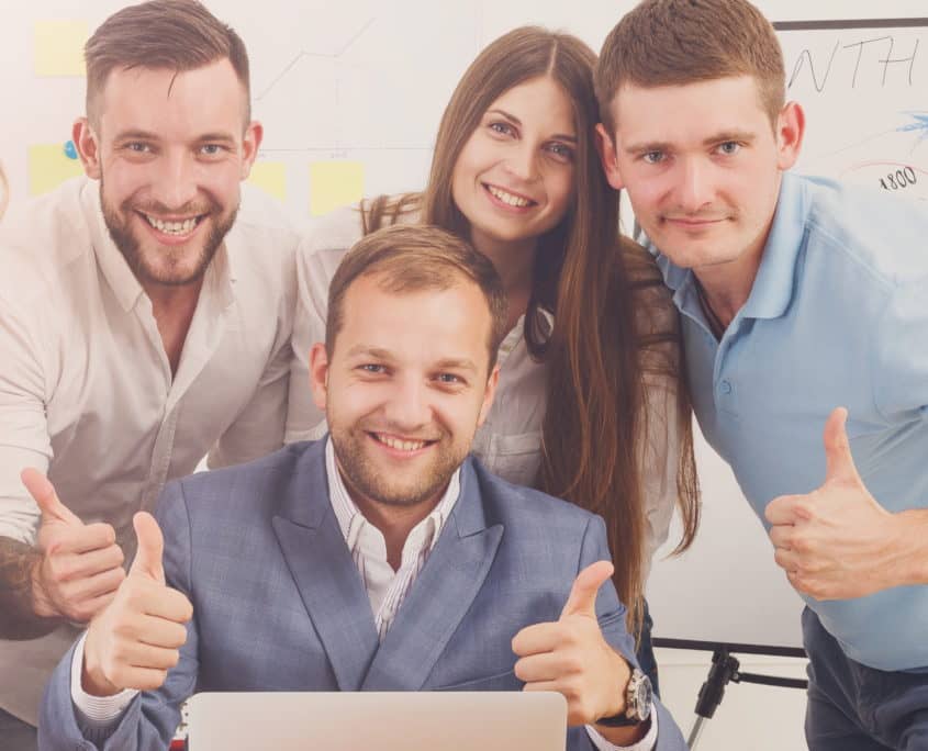 Happy business people team together near laptop in office This is how you will feel signing up for the Image Craft Newsletter.